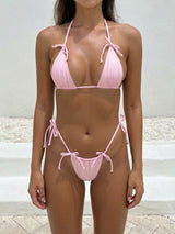 Woman wearing a pink string bikini from the front