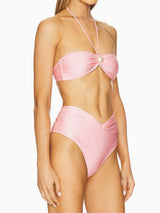 side view of a woman wearing a pink strapless bikini with a halter tie and a pearl embellishment on the bust