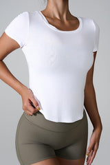 Close-up of a woman wearing a white cropped top and olive green shorts