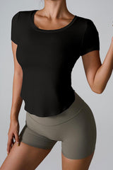 Woman wearing a black cropped top and olive green shorts