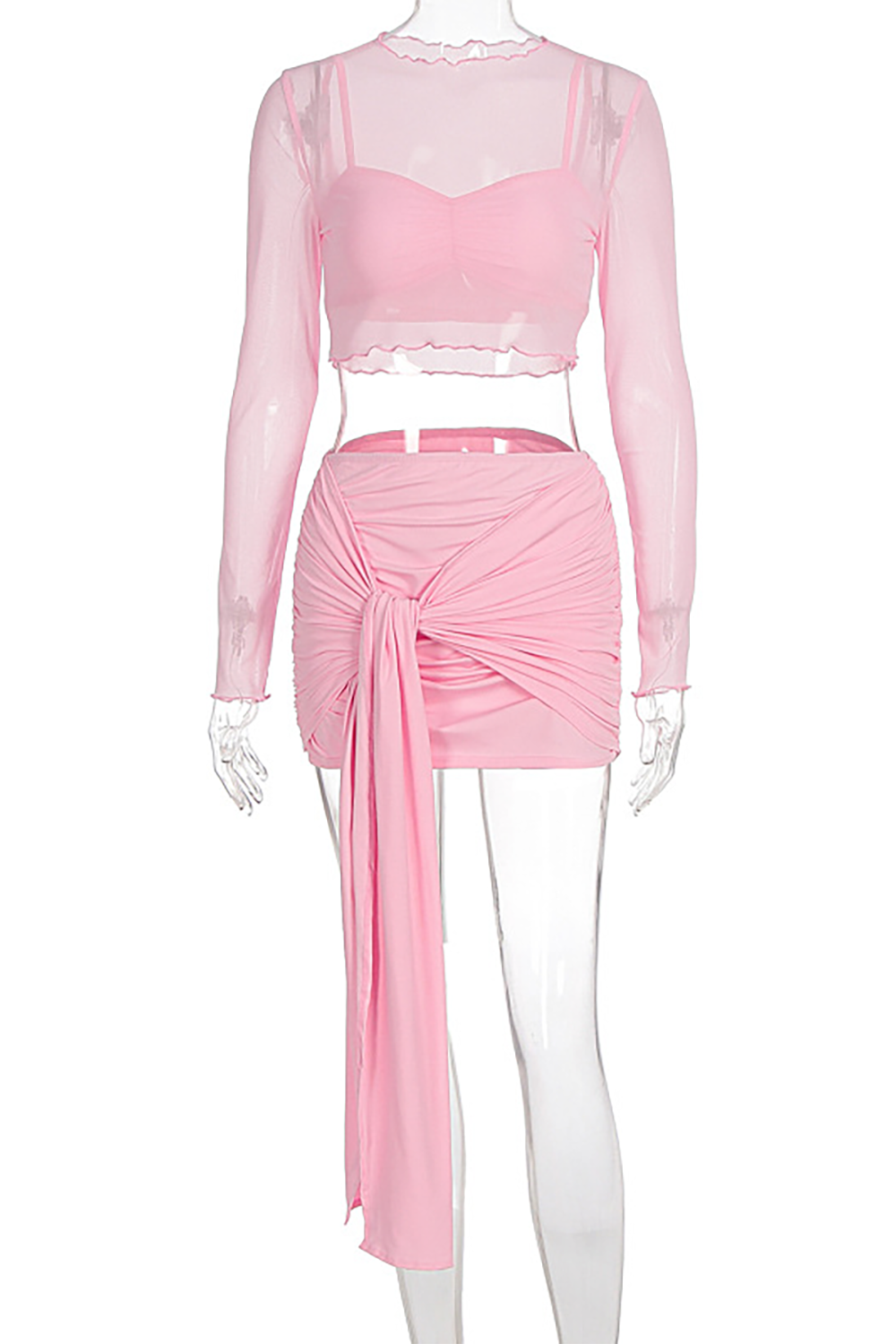 A pink sheer long-sleeved crop top and a pink ruched mini skirt with a tie detail displayed on a mannequin.