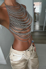 Woman in a silver chain halter top and gold pants