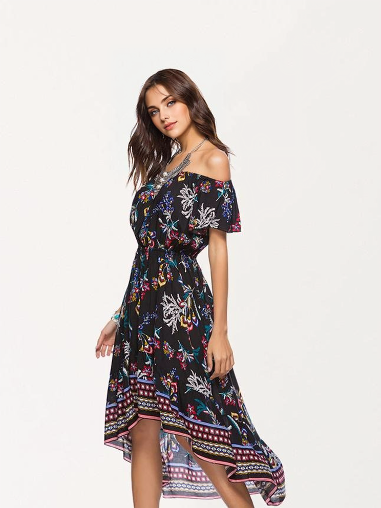 A woman models a black off-the-shoulder dress with a floral print and a high-low hem.