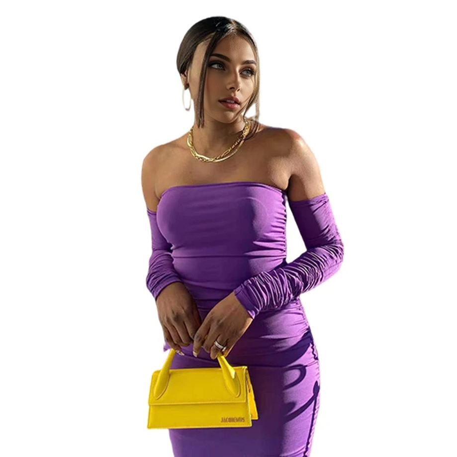 A woman wearing a purple off-the-shoulder ruched dress and holding a yellow purse.