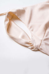 Close-up of the neckline and shoulder detail of a cream satin dress.