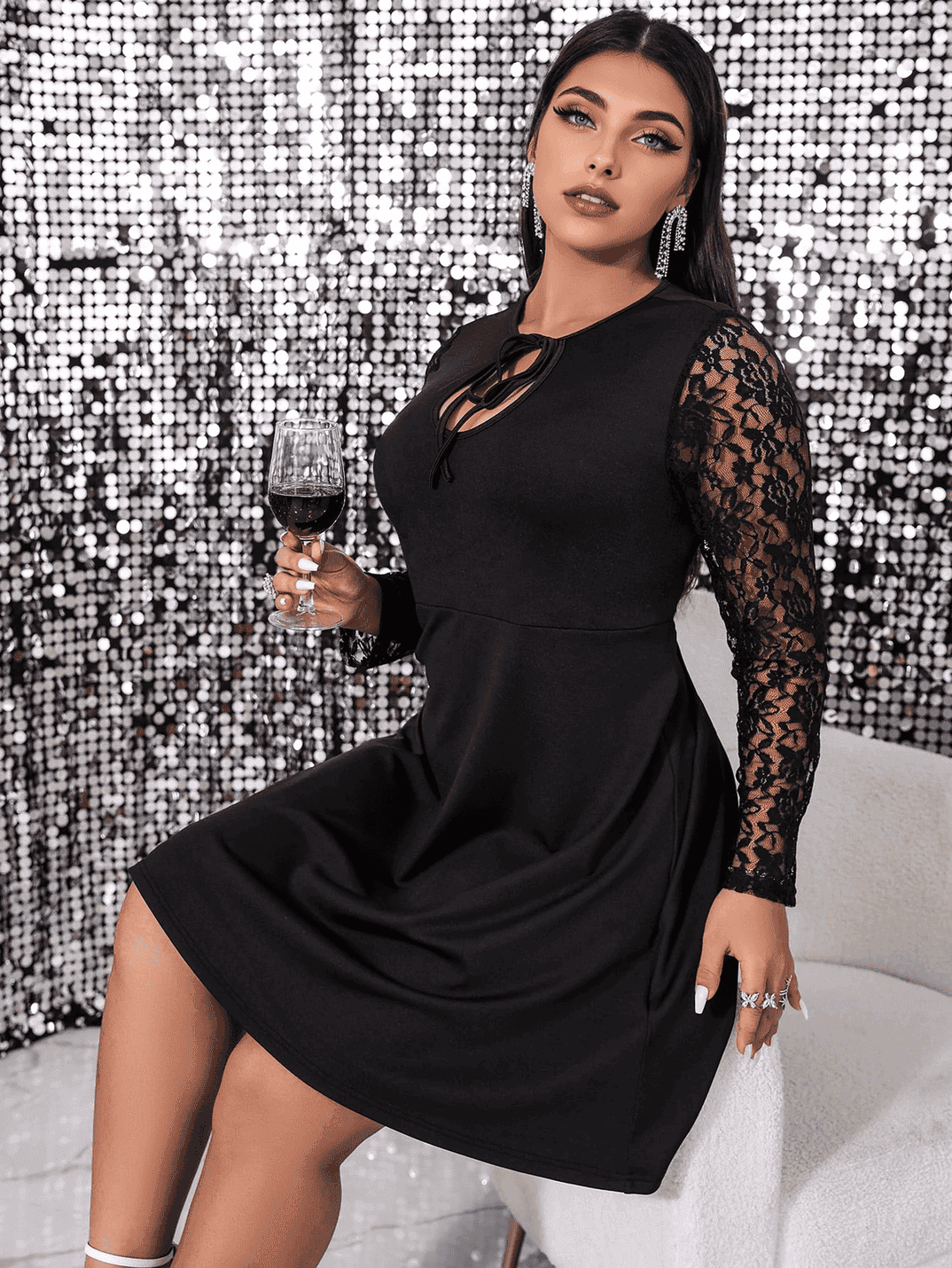 woman in black dress holding a glass of red wine