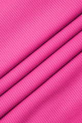A close-up of bright pink ribbed knit fabric.