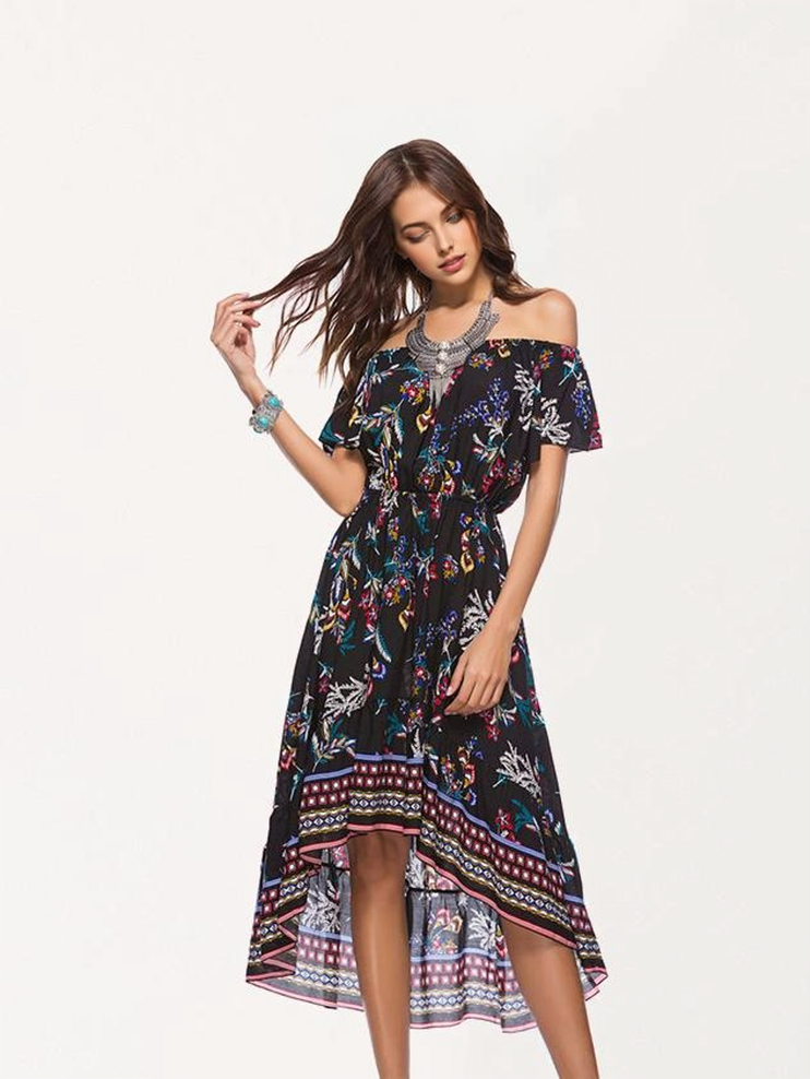 A woman with long brown hair models a black off-the-shoulder dress with a floral print.