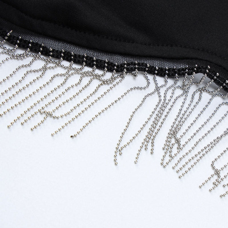 Close-up of the fringe detail on the black crop top, showing silver beads and chains.