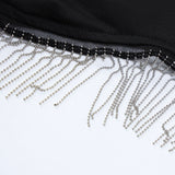 Close-up of the fringe detail on the black crop top, showing silver beads and chains.
