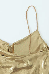 Close-up of the spaghetti strap and cowl neckline of a gold slip dress.