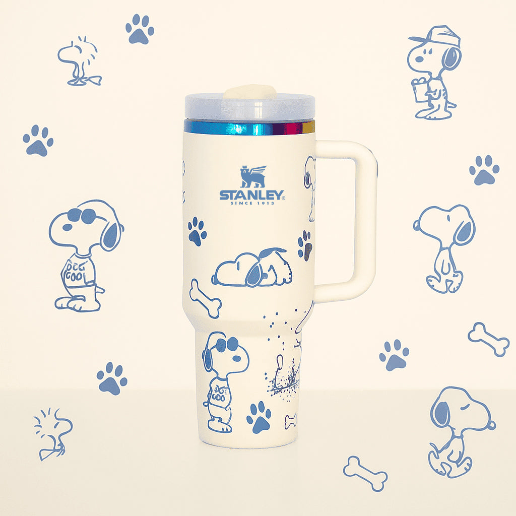 Stanley Snoopy 40 oz insulated tumbler in white with blue Peanuts illustrations, ergonomic handle, and straw - View 1 | Clistos