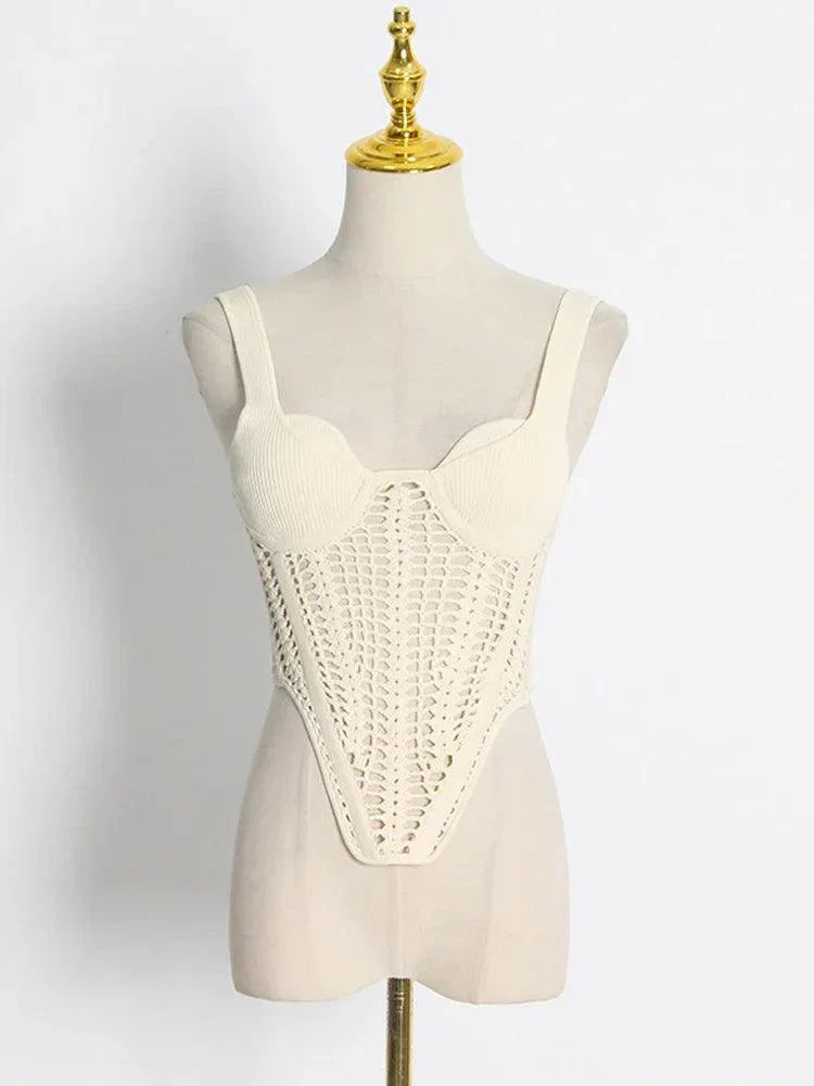 A cream knit top with a crochet overlay displayed on a mannequin.