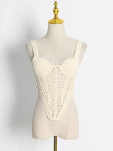 A cream knit top with a crochet overlay displayed on a mannequin.