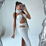 woman in a white halter neck crop top and matching maxi skirt with cut-out details