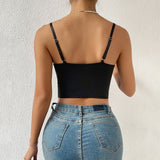 Back view of a woman wearing a black corset top and jeans.