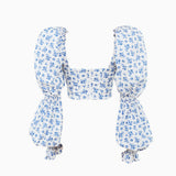 A white and blue floral print cropped top with long puff sleeves and a square neckline, shown flat with a zipper closure.