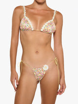 Woman wearing a floral bikini with white flower trim and yellow string ties