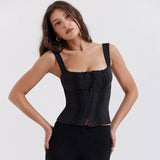 A woman wearing a black square-neck, sleeveless top with a ruched bust and tie detail.
