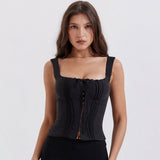 Close-up of a woman in a black ruched top with hook and eye closures.