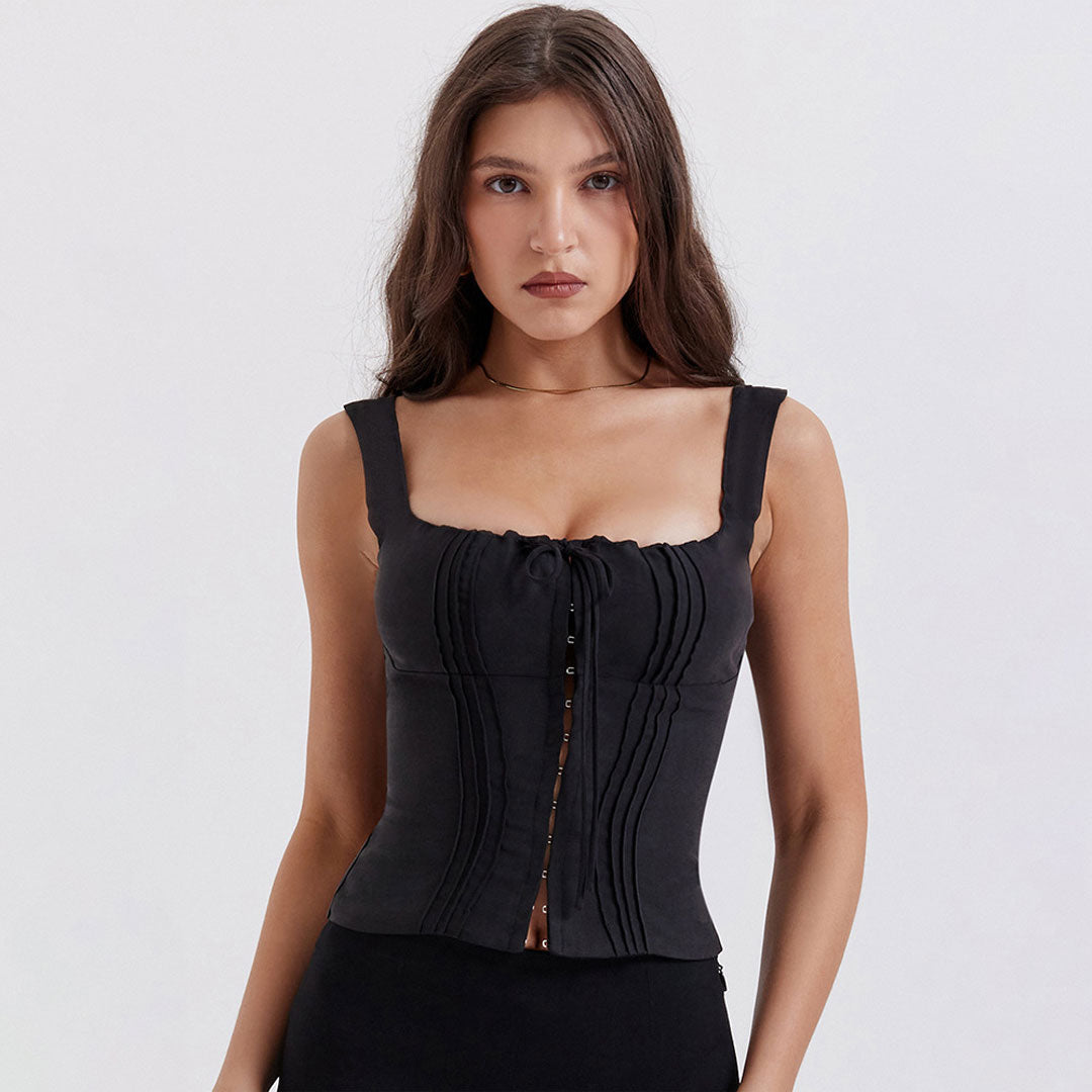 Close-up of a woman in a black ruched top with hook and eye closures.