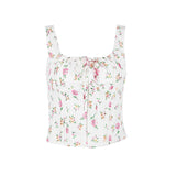 Front view of a white floral print corset top with spaghetti straps and a tie front.