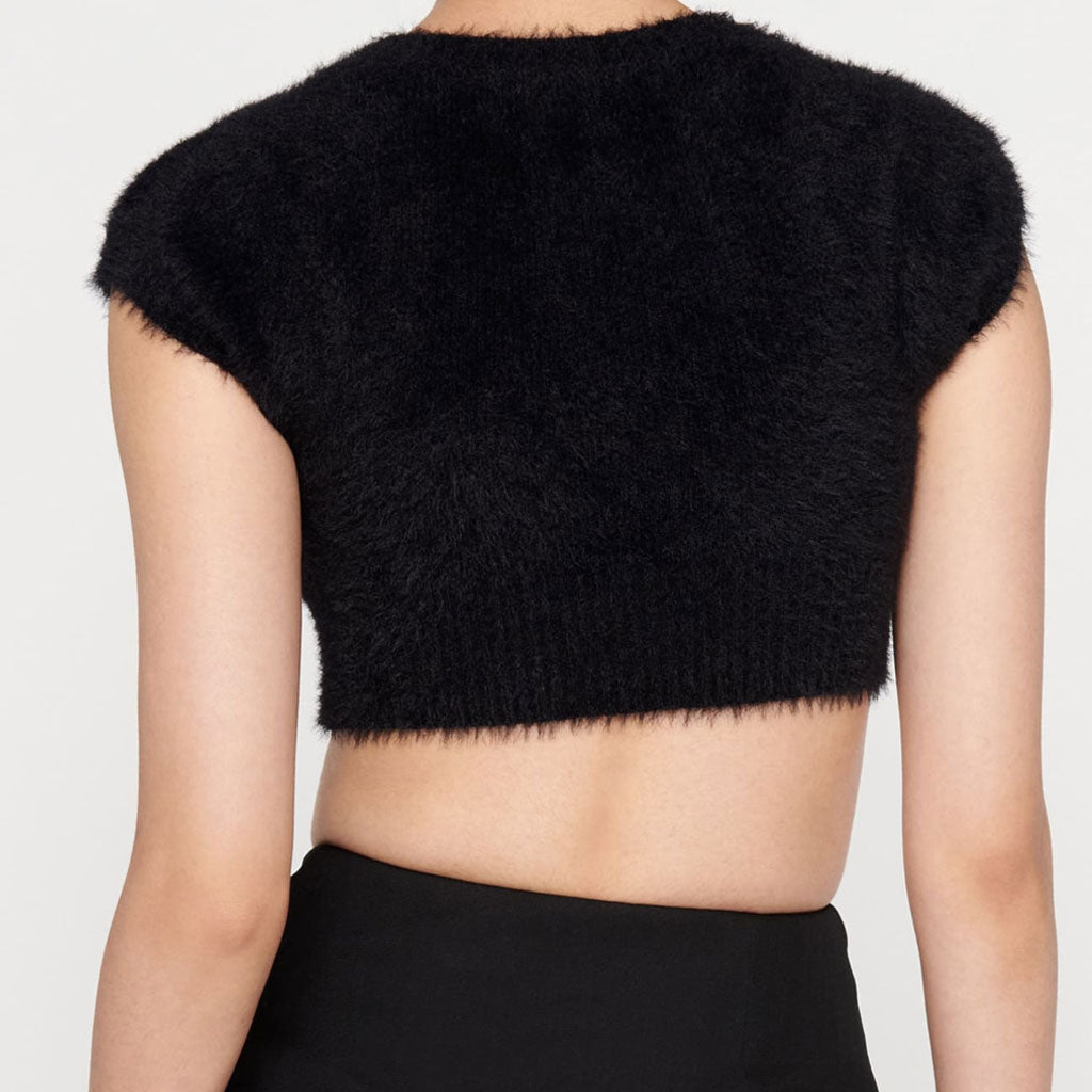 The back of a black fuzzy cropped short-sleeved cardigan.