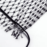 Close-up of the black mesh fabric with scattered rhinestones and fringe.