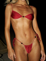 Woman wearing a red bikini with gold accents