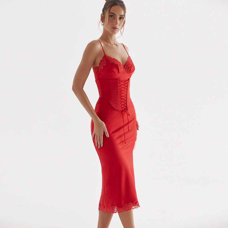 A woman in a red satin midi dress with lace trim and corset detailing is shown from the side against a white background.