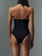 Back view of a woman in a black one-piece swimsuit