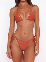 woman wearing a rust-colored bikini with eyelet details