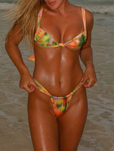 Woman in a colorful tie-dye bikini standing in the ocean