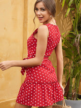 Woman turning to the side, showing the back of a red and white polka dot dress.