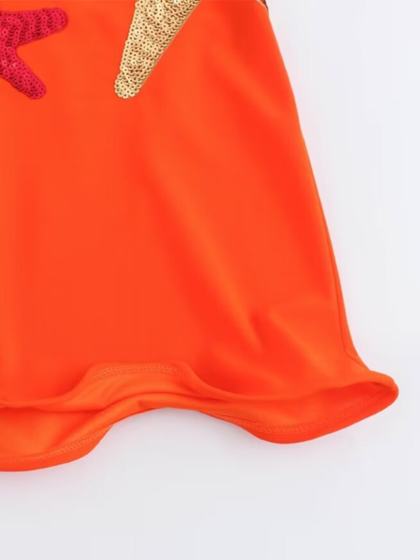 Close-up of orange dress ruffled hem