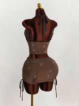 Back view of a brown sparkly halter neck crop top and ruched mini skirt set on a mannequin.