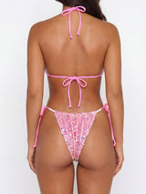 Back view of a woman in a pink sequined bikini with pearl accents.