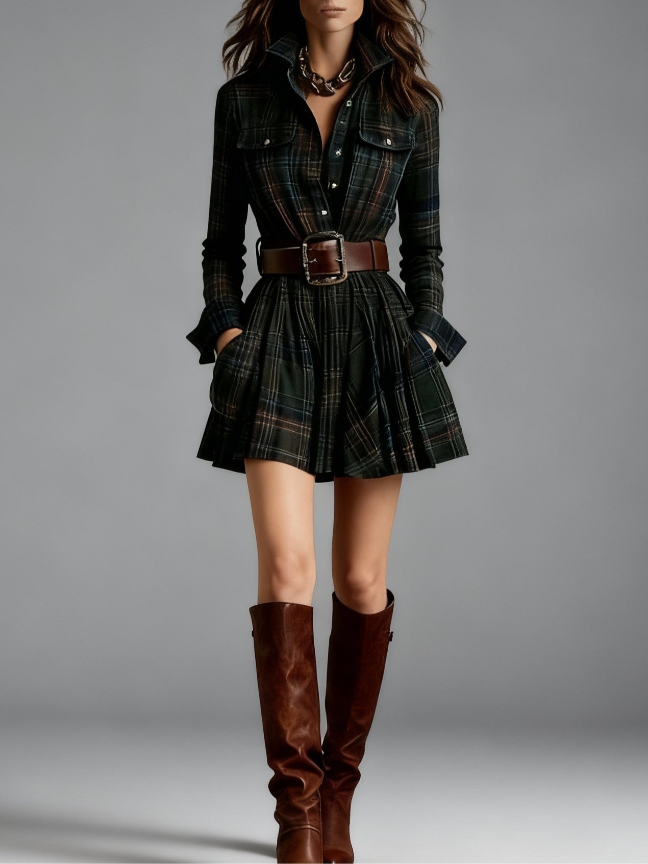 Model in a dark plaid shirt dress with a brown belt and boots