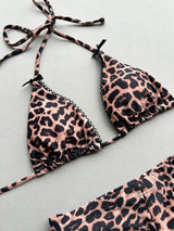 Close-up of a leopard print bikini top with bow accents and scalloped trim