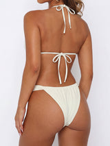 Back view of a woman wearing a cream bikini