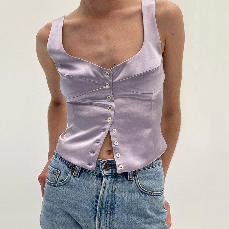 woman wearing a lavender satin top with a scoop neckline and button-down front, paired with blue jeans