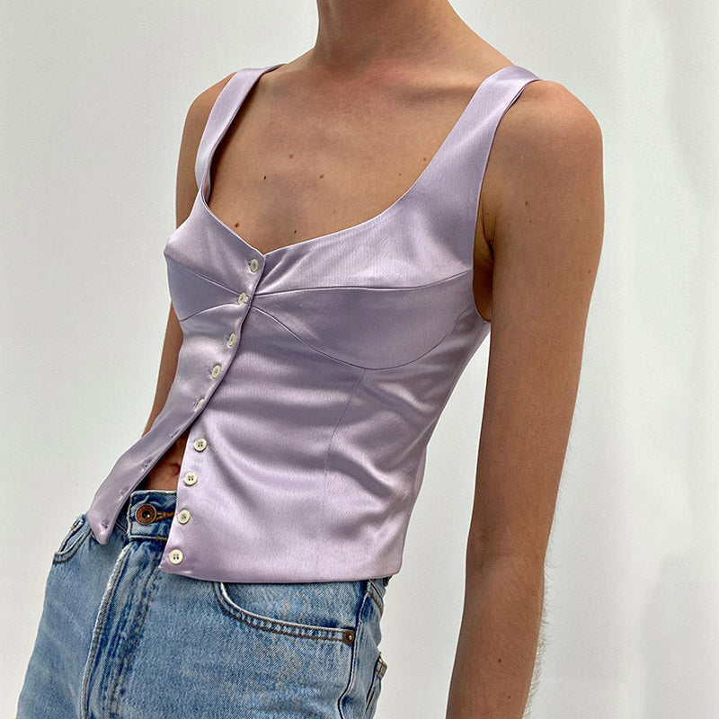 woman wearing a lavender satin top with a scoop neckline and button-down front, paired with blue jeans