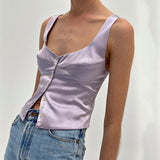 woman wearing a lavender satin top with a scoop neckline and button-down front, paired with blue jeans