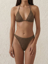 Woman wearing a brown textured triangle bikini with a halter neck and high-cut bottoms.