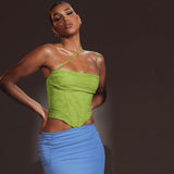 A woman poses with her hands on her hips, wearing a lime green asymmetrical strap top and a blue ruched skirt.