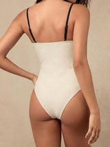 woman in a white and black one-piece swimsuit from the back