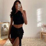 woman wearing a black one-shoulder ruched cropped top with a black sequined mini skirt