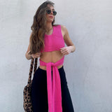 woman in pink knit crop top and black pants