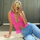 woman in pink knit wrap top and jeans taking a selfie