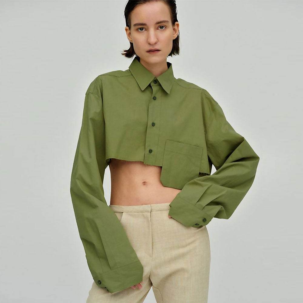 Woman wearing a green cropped button-down shirt with beige pants